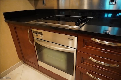 Kitchen with stainless steel oven, light tile patt