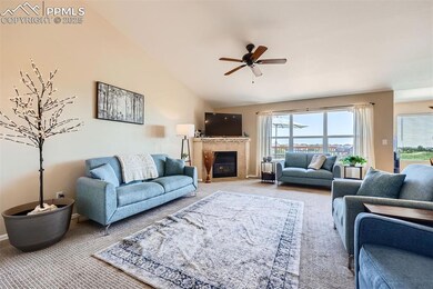 Carpeted living room with lots of natural light, vaulted ceiling and gas log fireplace