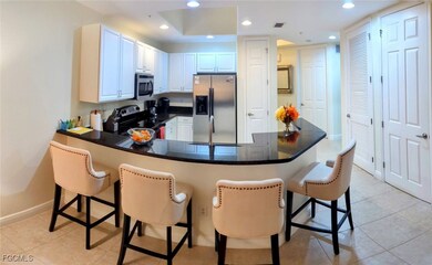 Kitchen with light tile patterned flooring, stainless steel appliances, a breakfast bar, recessed lighting, and a peninsula