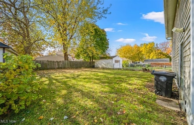 Fenced backyard featuring an outbuilding