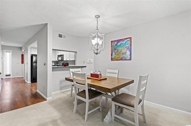 Dining area with baseboards, a textured ceiling, v