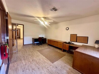Office featuring light hardwood / wood-style flooring, built in desk, ceiling fan, and a textured ceiling