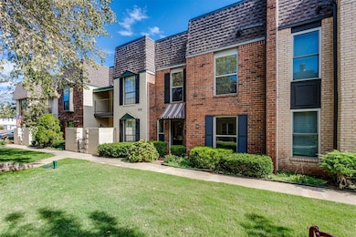 View of front facade featuring brick siding, a front lawn, mansard roof, and roof with shingles