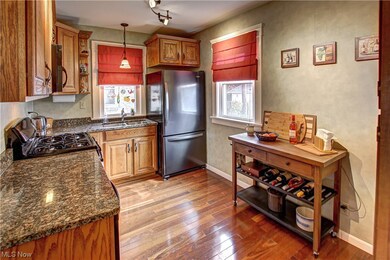 Kitchen with track lighting, range, stainless steel fridge, decorative light fixtures, and light wood-type flooring