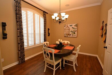 Dining room enhanced by hardwood laminate floors, raised ceilings, crown molding, access to the kitchen and plantation shutters.