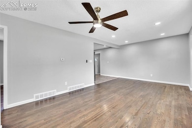 Empty room with ceiling fan, recessed lighting, wood finished floors, and a textured ceiling