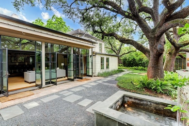  Floor to ceiling windows accentuate this outdoor space showcasing the grand oaks trees and lush landscaping.