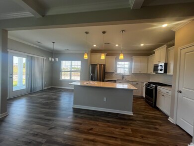 Kitchen featuring stainless steel appliances, a kitchen island, tasteful backsplash, white cabinets, and recessed lighting