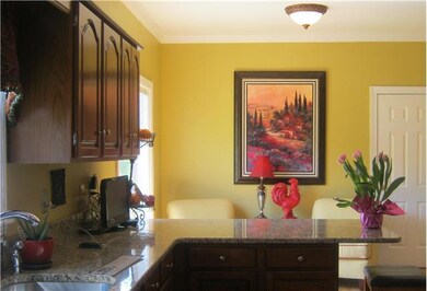 Upscale kitchen is sure to impress any chef!  Hardwoods continue throughout this room. Notice the granite counters!  There are also stainless steel appliances!! The breakfast bar is a nice feature!