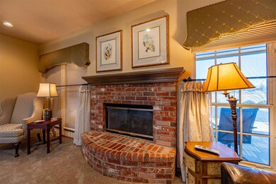Carpeted living room with a brick fireplace