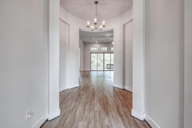 Corridor with a chandelier and light wood-style f