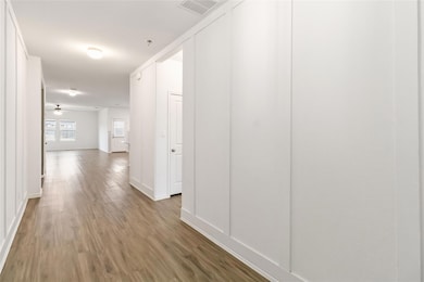 Hallway featuring wood finished floors, visible v