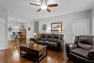 Living room with ceiling fan with notable chandeli