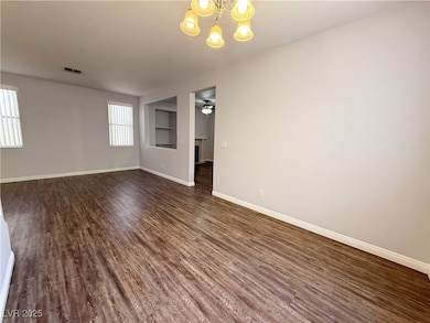 Spare room with a chandelier, dark wood finished f