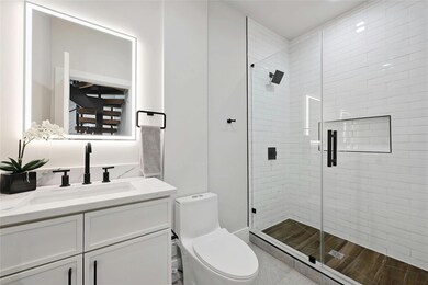 Full bathroom featuring toilet, a stall shower, a