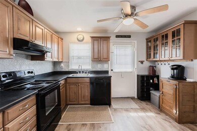 Kitchen featuring dark countertops, a sink, light 