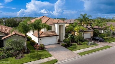 Mediterranean / spanish-style house with a tile roof, decorative driveway, a garage, stucco siding, and a front yard