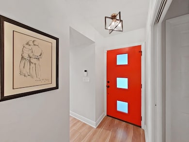 Impressive front foyer entry- New front door, lighting, flooring, baseboards, and paint.