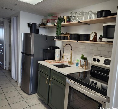 Kitchen featuring sink, backsplash, light tile pat
