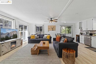 Living room with light hardwood / wood-style flooring, sink, and ceiling fan
