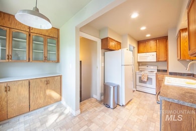 Kitchen featuring white appliances, recessed lighting, and glass insert cabinets