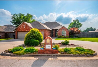 Traditional-style house with brick siding, driveway, an attached garage, and a shingled roof