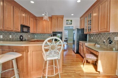 Kitchen features corian countertops and tile backs