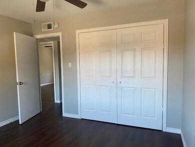 Unfurnished bedroom with ceiling fan, a closet, and dark hardwood / wood-style floors