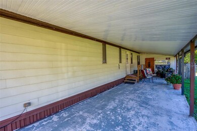 The extended carport includes a spacious covered side porch - great for outdoor seating, hobbies, or storage.