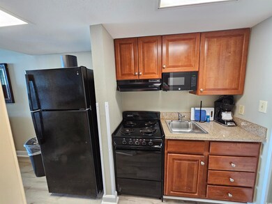 Kitchen with brown cabinetry, under cabinet range 