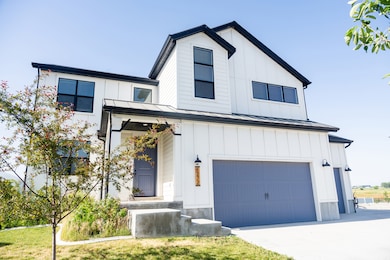 Modern farmhouse style home featuring board and batten siding, a standing seam roof, an attached garage, and a metal roof