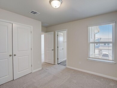 Unfurnished bedroom with light carpet, baseboards