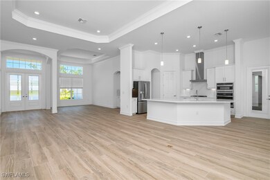 Kitchen with white cabinetry, hanging light fixtur