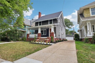 View of front of home featuring a garage, covered porch and a front yard