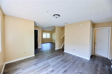 Empty room with wood finished floors, stairs, base