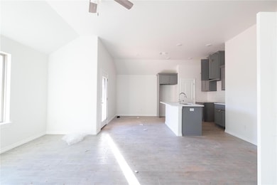Kitchen featuring a sink, gray cabinets, ceiling fan, plenty of natural light, and vaulted ceiling