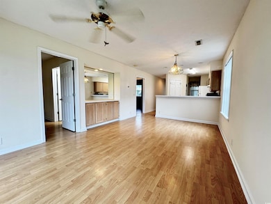 Unfurnished living room with light wood-style floors, ceiling fan, and baseboards