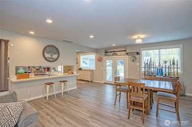 Expansive dining space flows to sliding doors, blending indoor comfort with outdoor charm