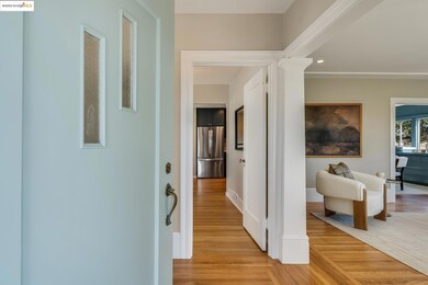 Corridor with light wood-style flooring, ornate columns, and recessed lighting