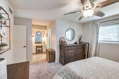 Bedroom with ensuite bath, light carpet, ceiling f