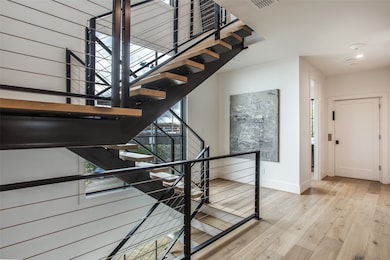 Staircase with wood finished floors and baseboards