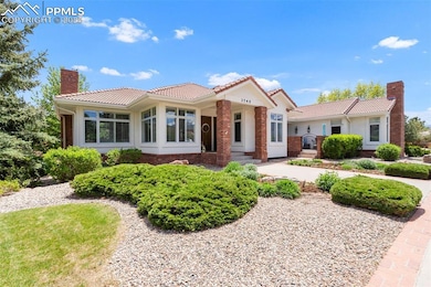 Single story home featuring a chimney, a tiled roof, stucco siding, and brick siding