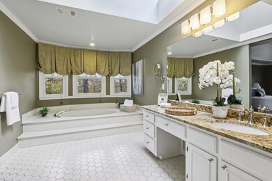 The Spa-Like Ensuite Bathroom features a Soaking Tub, Separate Glass Shower, Double Vanity, And Walk-In Closet.