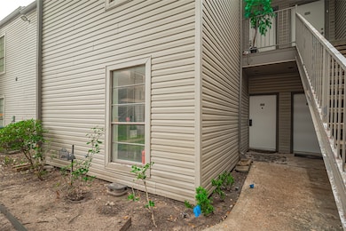 Tucked beneath a shaded stairwell, the front entrance to this ground-floor unit offers a sense of privacy and tranquility.