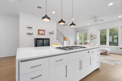 Kitchen with stainless steel gas cooktop, white c