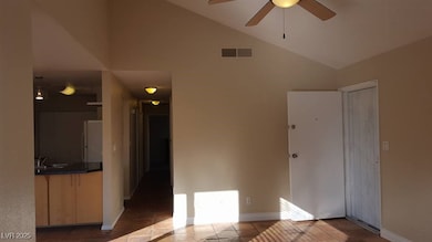 Unfurnished living room with high vaulted ceiling and dark tile patterned flooring
