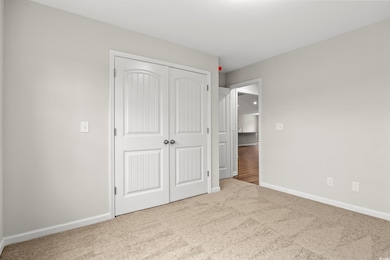 Unfurnished bedroom with carpet flooring and a clo