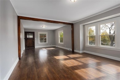 Dining room towards great room and beautifully refinished original wood floors,  solid wood front door and NOTE: updated vinyl, operable, double hung windows