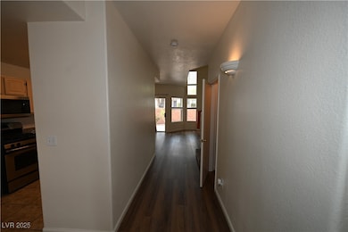 Hall featuring baseboards and dark wood-style floo