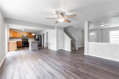 Living room with view of kitchen, stairs and front